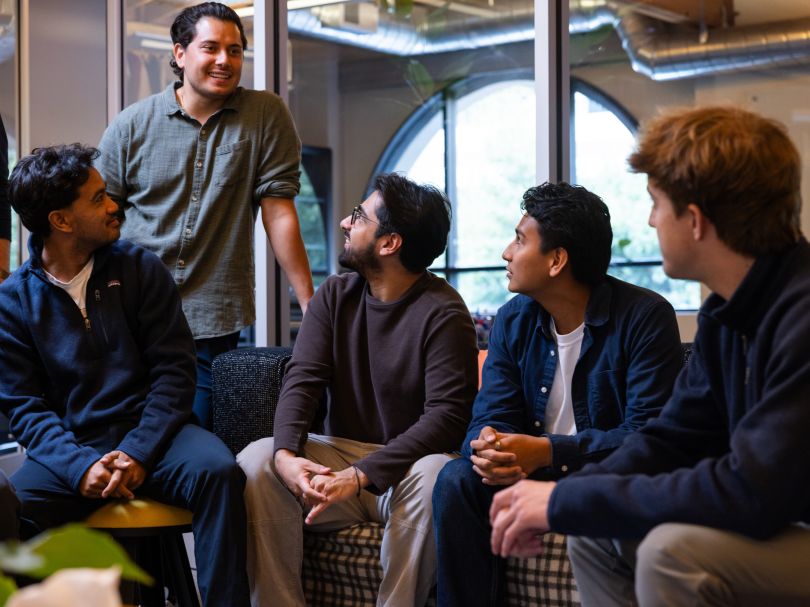 Several Rundoo team members chat while gathered together in the company’s office